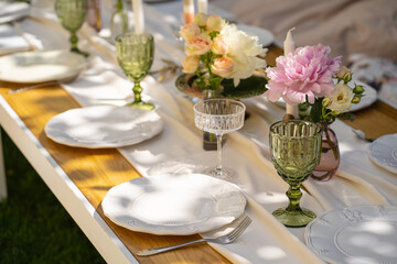 Holiday. Festive decoration. Table serving. Beautiful flower compositions. Green grass lawn. Summer pleasant meetings.