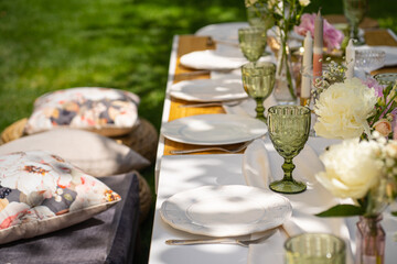 Holiday. Festive decoration. Table serving. Beautiful flower compositions. Green grass lawn. Summer pleasant meetings.