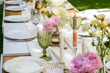 Holiday. Festive decoration. Table serving. Beautiful flower compositions. Green grass lawn. Summer pleasant meetings.