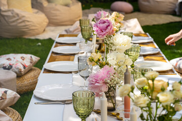 Holiday. Festive decoration. Table serving. Beautiful flower compositions. Green grass lawn. Summer pleasant meetings.