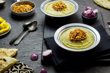 Arabic cuisine, Egyptian fava beans and herbs dip ( Bessara). It contains fava beans, onion, garlic and fresh herbs. Served with crispy fried onions,bread,pickles and fresh onios.