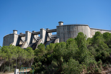 Fototapeta na wymiar El Grado Dam, Hydro-Electricity Generation, Huesca, Spain, a concrete hydro-electric reservoir dam, clear blue sky