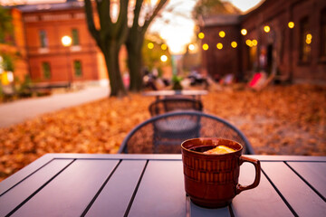 Lodz, Poland: A cup of hot drink on the table in the Ksiezy Mlyn historic distric during autumn evening