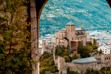 Fototapeta premium Medieval Valere basilica seen through main gates of Tourbillon Castle located in Sion city, canton Valais, Switzerland