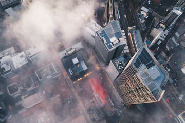 Aerial overview of fog and mist amongst the city buildings