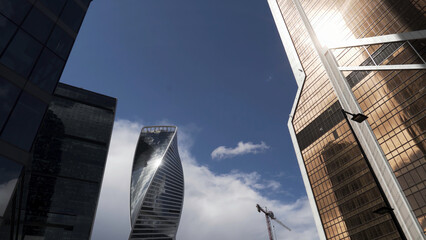 Low angle view of Moscow-City skyscrapers, Russia. Action. Bottom view of business district with high rise skyscrapers on blue sky background, modern office urban buildings in sunlight.