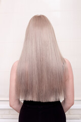 Naklejka premium Female back with long, straight, blonde hair, in hairdressing salon 