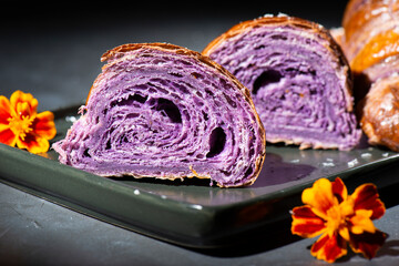 Fresh baked homemade Ube Croissants using flavouring and purple yam powder and three book folds, lightly sprinkled with coconut.