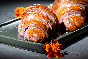 Fresh baked homemade Ube Croissants using flavouring and purple yam powder and three book folds,...