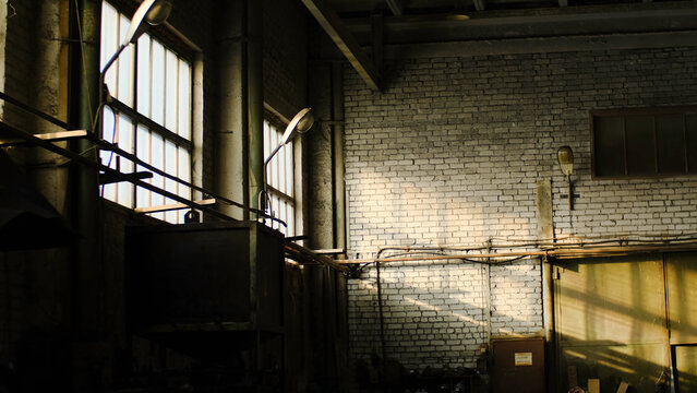 Old abandoned warehouse of industrial enterprise. Stock footage. Small abandoned room of old warehouse cluttered and illuminated by sun rays making their way out of windows