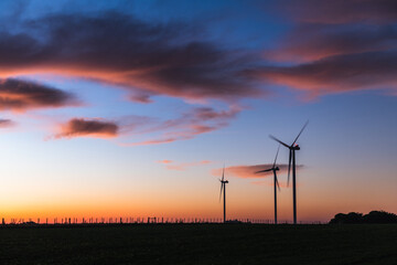 Obraz premium Silhouette of three modern windmills under a blueish sunset on the outskirts of Kiyú, San José, Uruguay