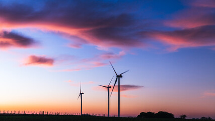 Silhouette of three modern windmills under a blueish sunset on the outskirts of Kiyú, San José,...