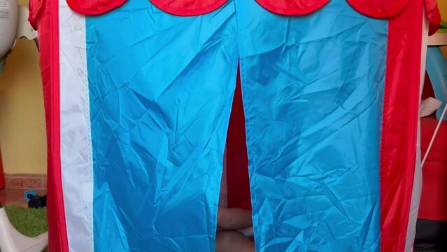 Adoable two year old afro european child playing in his toy tent surprising dad.