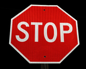 A stop sign with dark sky background.