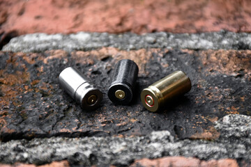 9mm pistol bullet shells on brick floor, soft and selective focus on black bullet shell, concept for searching a key piece of evidence in a murder case at the scene.