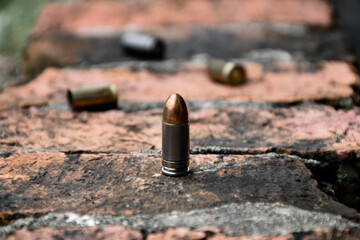9mm pistol bullets and bullet shells on brick floor, soft and selective focus, concept for searching a key piece of evidence in a murder case at the scene.