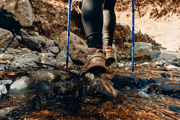 woman hiker legs stand on mountain peak rock