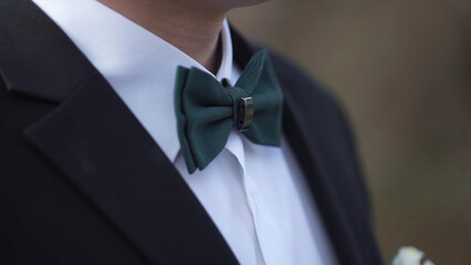 Close-up on nerd, man in bow tie. Man's hands touches bow-tie on a suit or tuxedo. man in a shirt and bow tie