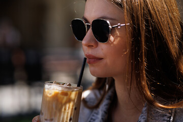 Pretty young hipster woman in stylish glamorous black glasses in trendy blue denim jacket with...
