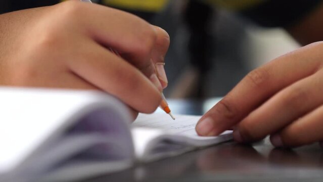 school girl writting with pen in notebook