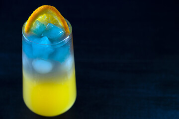 Non-alcoholic cocktail made from orange juice and blue Thai tea. Cubes in the form of stars. Summer refreshing drink. High quality photo