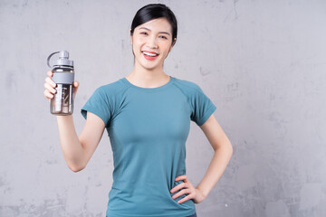 Photo of young Asian woman holding water bottle