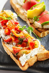 Tasty bruschetta with fish and baked peppers
