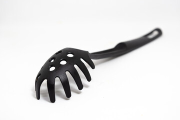 One whole kitchen tool black plastic nylon spaghetti spoon isolated on white