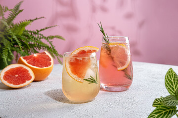Summer refreshing sparcling cocktails with grapefruit. Lemonade garnished with fresh rosemary. Summer beverage with sparkling water and grapefruit slices.