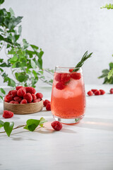 Summer refreshing non-alcoholic cocktails. Raspberry lemonade garnished with fresh rosemary. Summer raspberry beverage with sparkling water. Copy space.