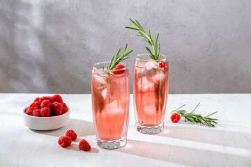 Summer refreshing non-alcoholic cocktails. Raspberry lemonade garnished with fresh rosemary. Summer raspberry beverage with sparkling water. Copy space.