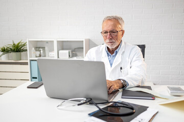 Experience doctor in ambulance sitting in front of his laptop and  work