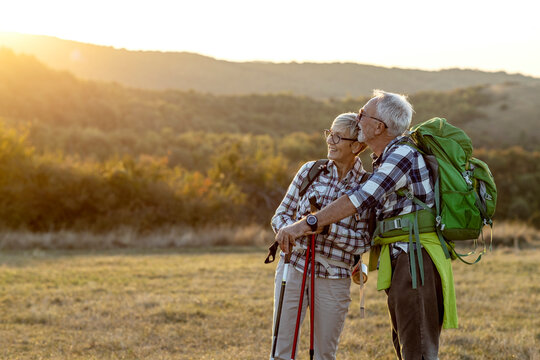 Couple of mature hikers talking at the field at the end of day