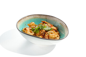 Pan asian food - udon with prawn, chicken wok on white background. Noodle with chicken and prawn in ceramic bowl. Indonesian wok with udon noodles. Spicy thai dish from noodle with shrimp and chicken.