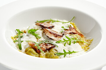 Mushroom ravioli and cheese sauce isolated on white background. Italian dish - ravioli with porcini and creamy espuma on white plate. Restaurant dishes with wild mushroom.
