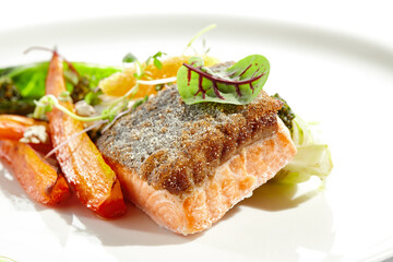 Healthy food - salmon fillet with roasted chinese cabbage and carrot. Clean eating - trout with garnish from vegetables and cream cheese and caviar. Fish steak and vegetables on white plate.