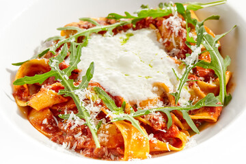 Italian pasta pappardelle with bolognese sauce  and parmesan isolated on white background. Pasta tagliatelle with meat ragu and creamy espuma with arugula. Minced beef in tomato sauce with pasta.
