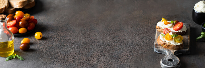 Bruschetta with cream cheese and tomato s on cutting board, rustic style