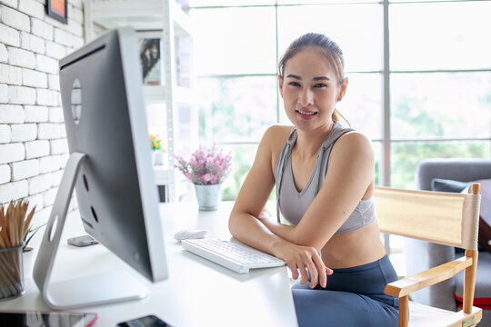 Young Asian woman using laptop computer checking social media application on website online at home, feel relax and enjoy communicate and discuss  in living room.
