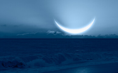 Ramadan concept - Crescent moon over the tropical sea wave at night "Elements of this image furnished by NASA"