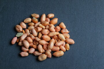 many groups of peeled peanuts on black background
