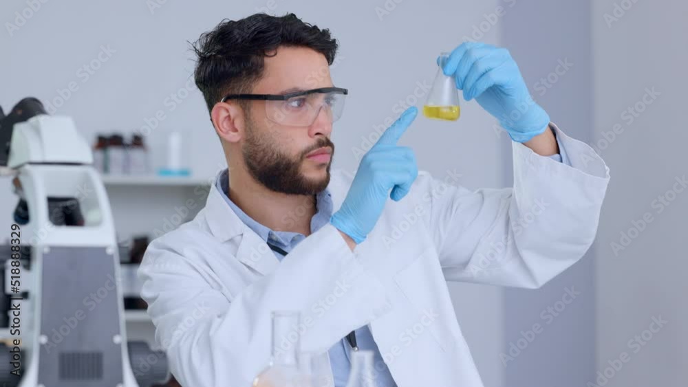 Poster serious male scientist analyzing liquid in a beaker in a laboratory. professional biochemist testing
