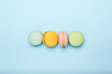 multi-colored macaroons on a blue background . Top view