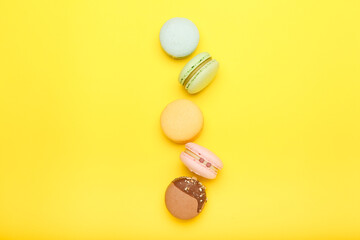multicolored macaroons on a yellow background. Top view
