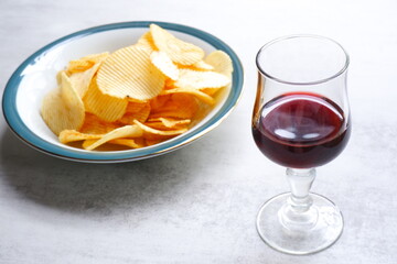 赤ワインのグラスと、ボウルに盛ったポテトチップス