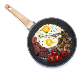 Fried eggs and bacon on a frying pan isolated on white background