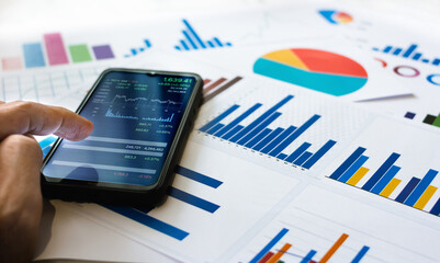 Close up view, asian businessman use finger touching on mobile screen to cheak set index of stocks...