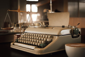 Focus on old sheet of paper on old typewriter with scales of justice in old lawyer's office,  sepie...
