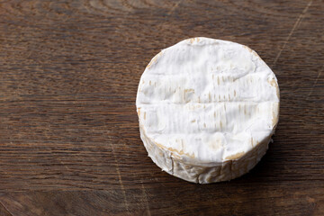 Brie type of cheese. Camembert cheese on a wooden table. Fresh Brie cheese. French cheese.
