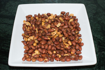 Roasted peanut or moong Fali. Masala peanuts in white bowl or plate.  - obrazy, fototapety, plakaty